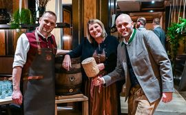Relaunch 16.2.23 Katharina Kramer und ihre Kollegen des Platzl Hotels stehen in bayrischer Tracht vor einem Bierfass.