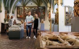 Bayrisches Nationalmuseum Ein Paar und ein anderer Besucher betrachten die Ausstellungsstücke im Bayerischen Nationalmuseum.