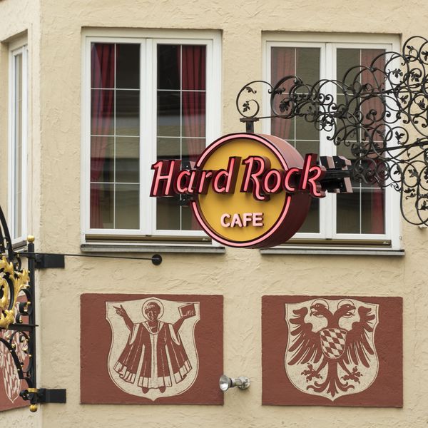Sign of the Hard Rock Café on Platzl in front of a beautiful house facade.