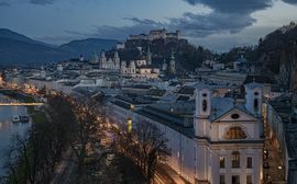 Nächtlicher Blick auf die Salzburger Altstadt mit dem Fluss Salzach und der Festung Hohensalzburg.