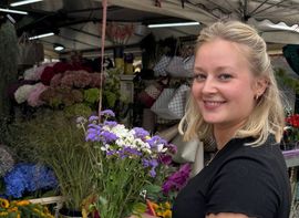 A young woman with a bouquet of flowers at the Viktualienmarkt