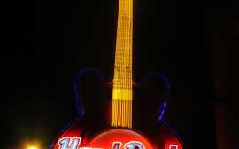 A bright sign of the Hard Rock Café in Munich in the shape of a guitar.