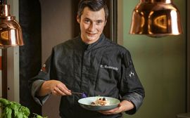 Tino Nawrocki_2 Souschef Tino Nawrocki präsentiert eine im tiefen Teller angerichtete Speise.