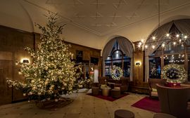 Weihnachtlich geschmückte Lobby mit einem Weihnachtsbaum im Platzl Hotel München.