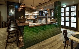 The dark green bar of the restaurant Ayinger Wirthaus in the Marias Platzl Hotel