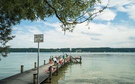 Steg am Starnberger See mit Badegästen.