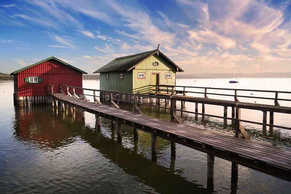 Bunte Bootshäuschen mit Steg am Ammersee bei München.